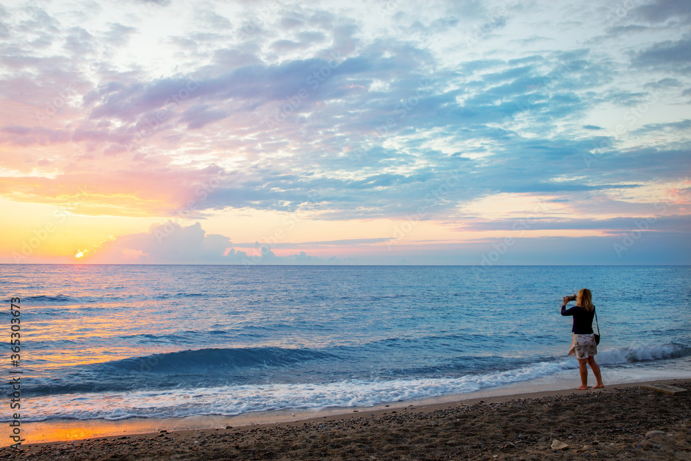 Woman making photo at sunrise (sunset)
