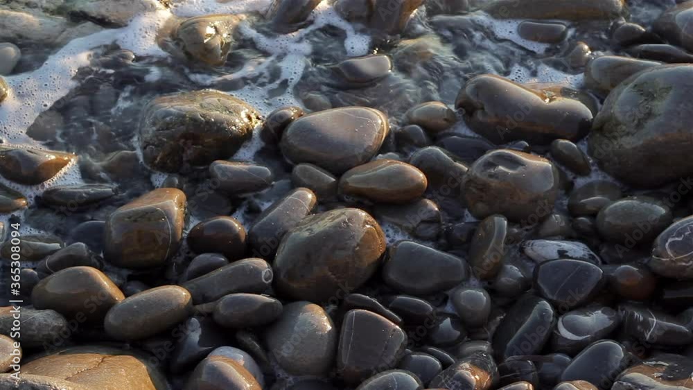 Stones at the beach with sea waves splashing. Travel vacation vibes. Summer relaxation. Stones at the beach with sea waves splashing. Travel vacation vibes. Summer relaxation.