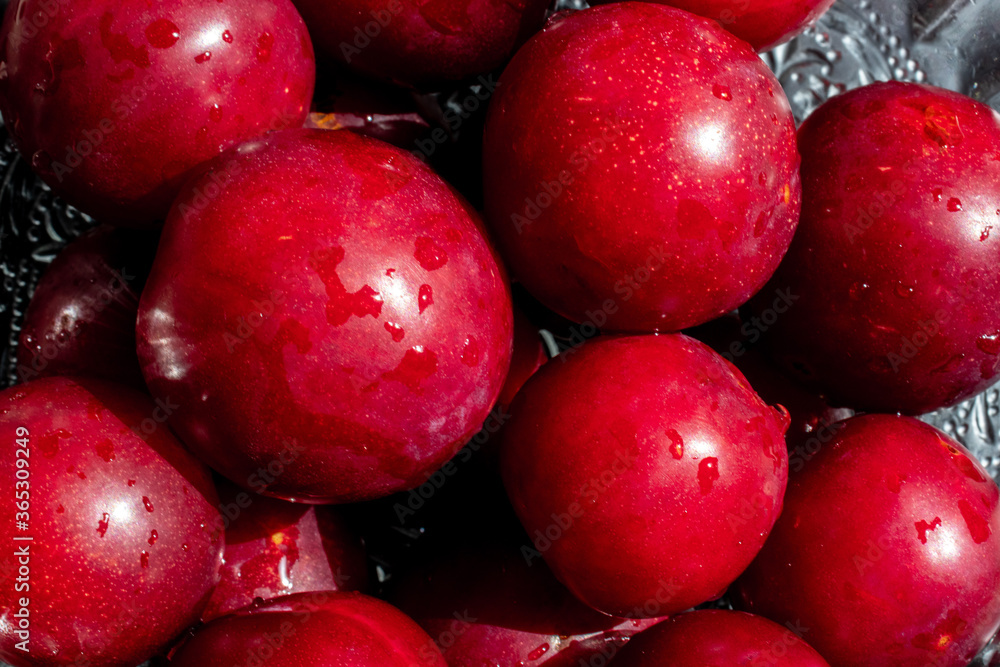 red plums with a black wooden background red plums with a black wooden background