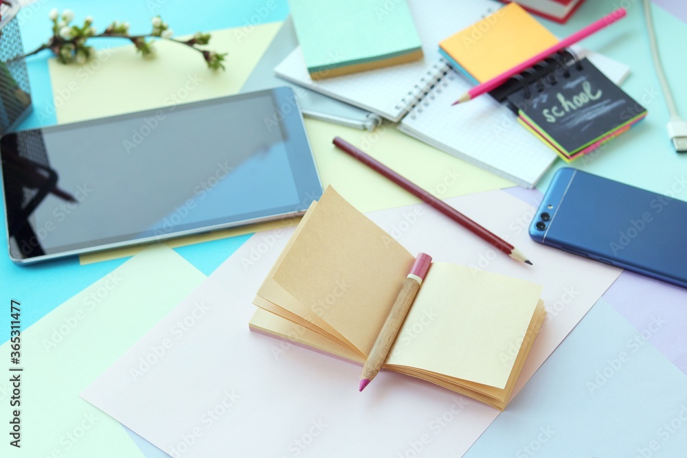 School stationery, tablet, phone on the desk, home schooling concept, part interior children's room, back to school School stationery, tablet, phone on the desk, home schooling concept, part interior children's room, back to school