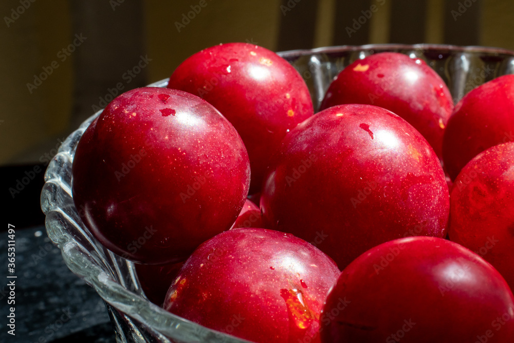 red plums with a black wooden background red plums with a black wooden background