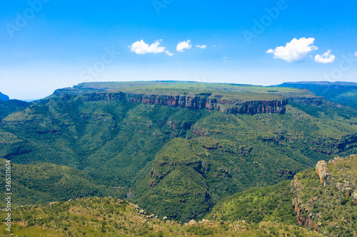 Aerial panoramic view of rugged mountain range on a clear day, with mountain plateau in the background.
