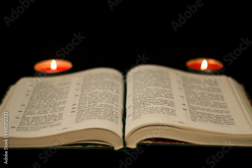A Holy Book of Islam; Quran awith Turkish translation, 2 candles on both sides. / Isolated black background