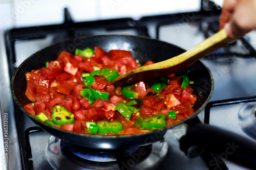 Cooking traditional turkish food menemen / tomatos and pepper in pan