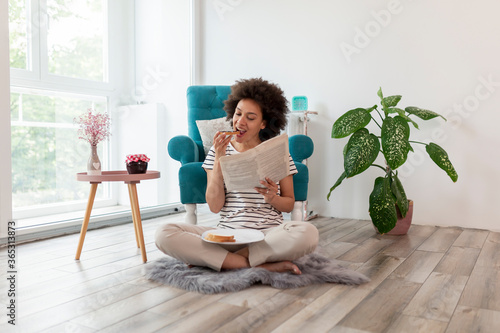 Woman reading newspapers and having breakfast