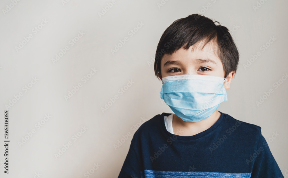 Portrait kid face wearing medical face mask, Mixed race child boy with beautiful brown eyeswearing blue face mask looking at camera, Little boy stay at home during covid-19 lock down. Portrait kid face wearing medical face mask, Mixed race child boy with beautiful brown eyeswearing blue face mask looking at camera, Little boy stay at home during covid-19 lock down.