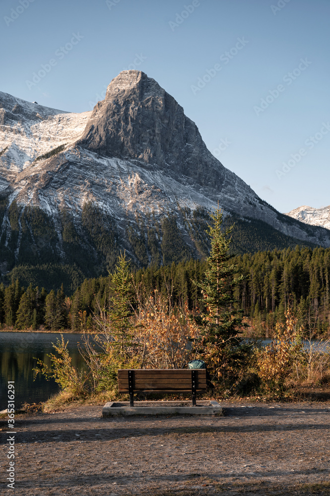 Mount Rundle with wooden bench on Rundle Forebay in autumn at Canmore Mount Rundle with wooden bench on Rundle Forebay in autumn at Canmore
