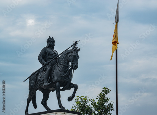 The Statue of King Maharana Pratap and his horse Chetak. The text on yellow flag had name location of the organization who manages the place. photo