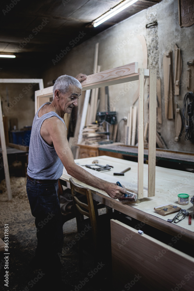 Older man, carpenter in his workshop