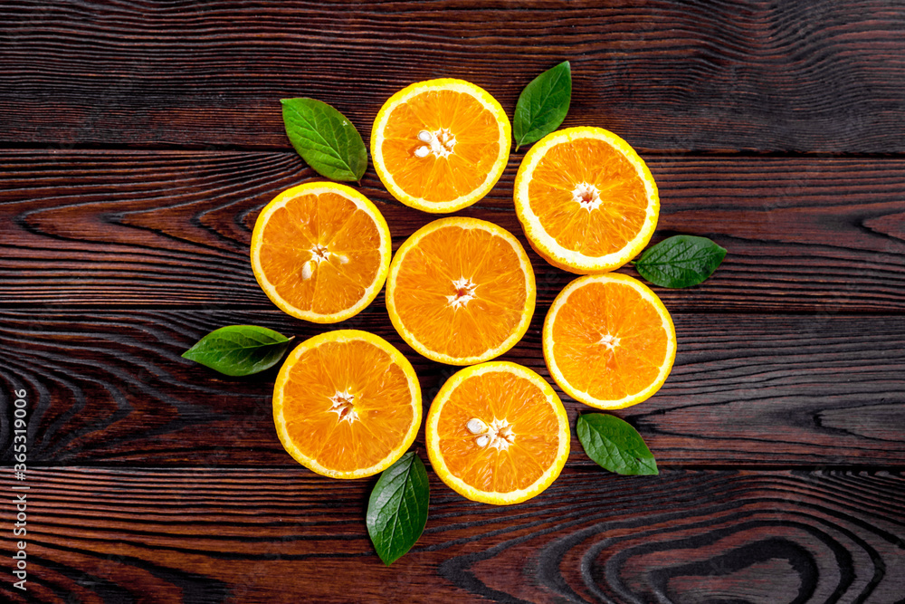 Concept of orange slices with leaves on dark wooden background top view flat lay copy space Concept of orange slices with leaves on dark wooden background top view flat lay copy space