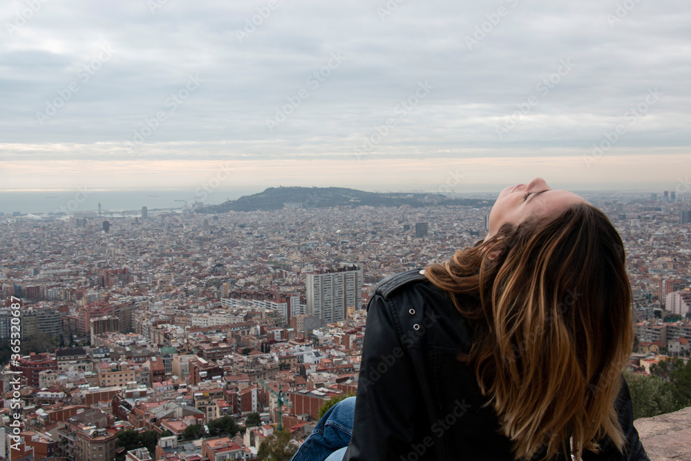 happy girl enjoys the views of a viewpoint in the city of Barcelona