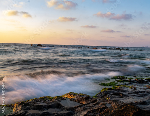 water splash on rocks sunset over the sea