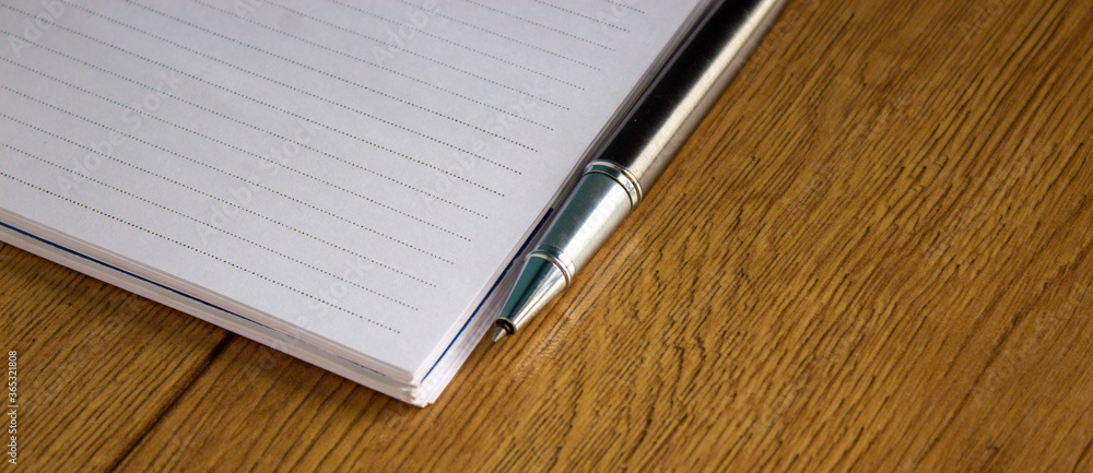 Notebook and pen on wood table. Business and education concept. Notebook and pen on wood table. Business and education concept.