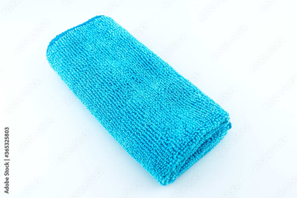 Light blue microfiber fabric lying in the middle, isolated on a white background, top view. Light blue microfiber fabric lying in the middle, isolated on a white background, top view.