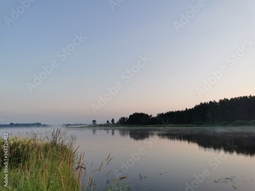 sunset over the river with forest reflection  grass and reeds on coast line. Illustration of russian nature and landscapes