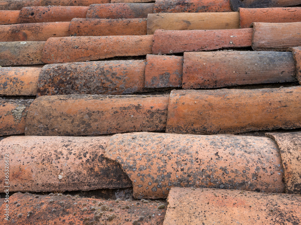 Detail of a rustic roof with irregular tiles Detail of a rustic roof with irregular tiles