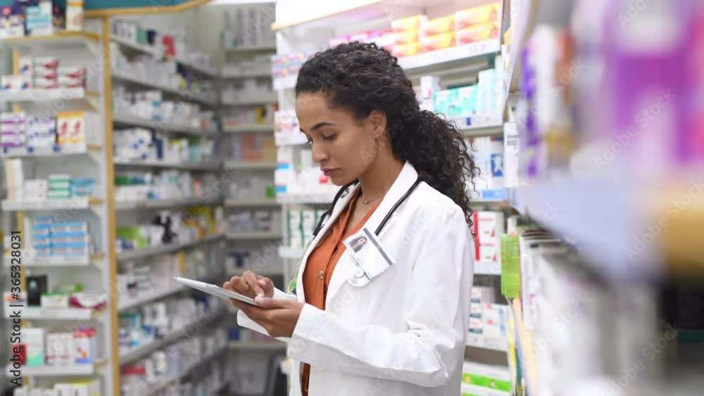 Happy friendly multiethnic pharmacist doing inventory in a provided and modern pharmacy while looking at camera. Portrait of african smiling doctor woman working in drugstore with digital tablet. Happy friendly multiethnic pharmacist doing inventory in a provided and modern pharmacy while looking at camera. Portrait of african smiling doctor woman working in drugstore with digital tablet.