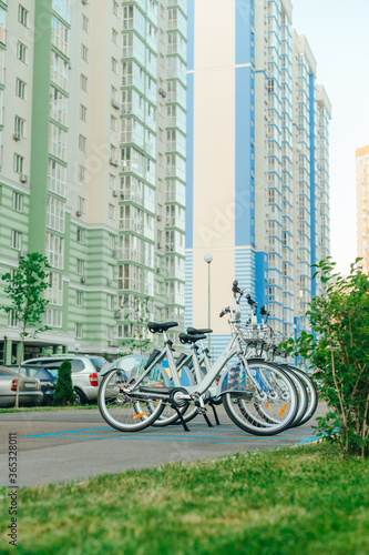 Row of bicycles for sharing on the background of colorful apartment buildings. Eco transport. Bicycle rental concept