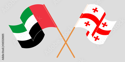 Crossed and waving flags of Georgia and the United Arab Emirates