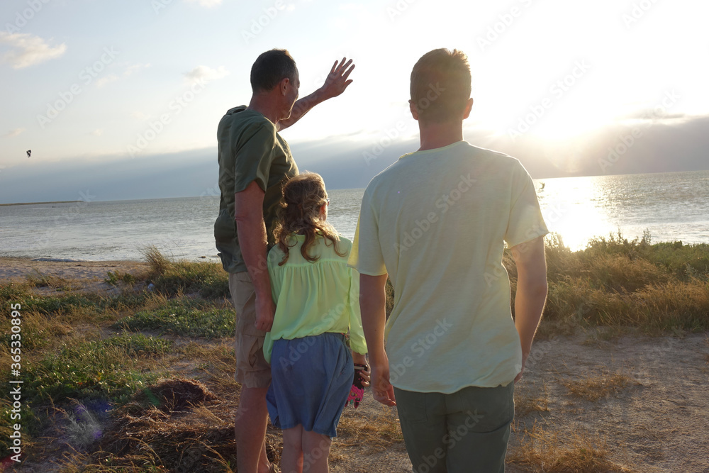 family on the beach watching the sunset family on the beach watching the sunset