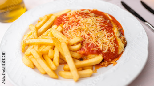 Bife à Parmegiana. Acompanhado de batatas fritas e azeite.