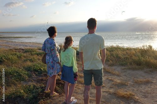 family on the beach watching the sunset