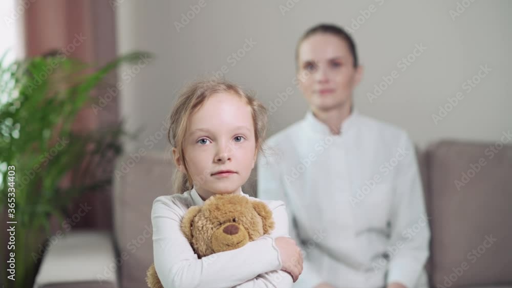 Closeup sick child holds a toy. Against background of blurred image of doctor Closeup sick child holds a toy. Against background of blurred image of doctor