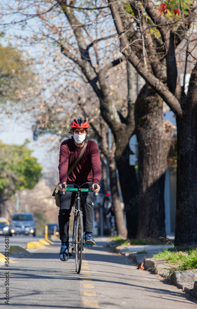 Cyclist riding a bicycle with face mask on a sunny day