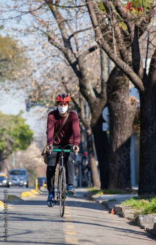 Cyclist riding a bicycle with face mask on a sunny day