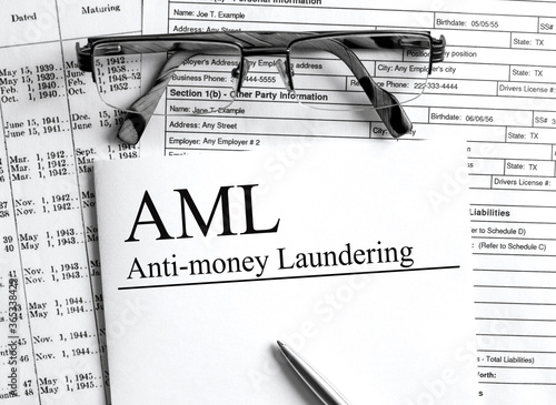 Paper with text AML Anti Money Laundering on a table photo