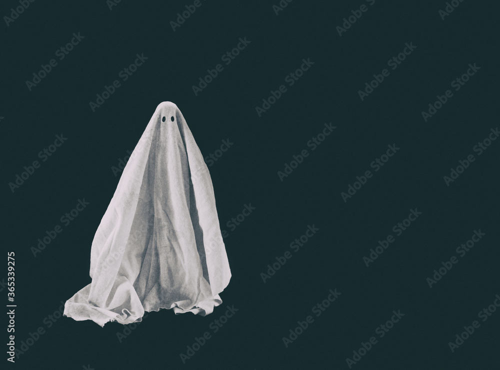 Halloween ghost in a sheet on dark background Halloween ghost in a sheet on dark background