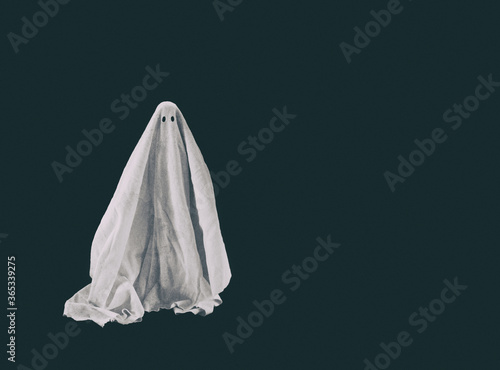 Halloween ghost in a sheet on dark background