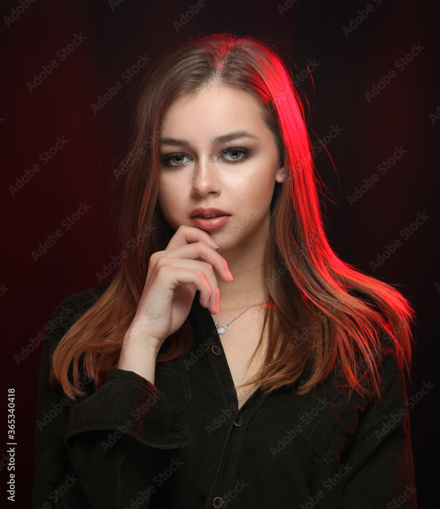 Girl in a men's black shirt on a dark background with red highlighting hair Girl in a men's black shirt on a dark background with red highlighting hair