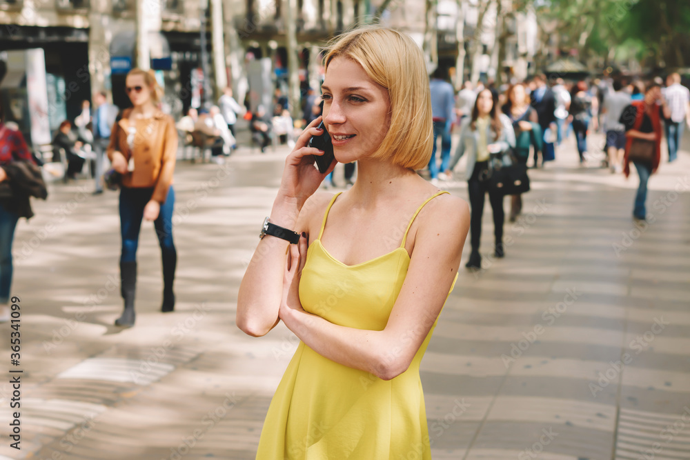 Gorgeous young woman talking on her smart phone while standing in city street with people walking ,modern businesswoman having cell phone conversation outdoors, female hipster calling via telephone Gorgeous young woman talking on her smart phone while standing in city street with people walking ,modern businesswoman having cell phone conversation outdoors, female hipster calling via telephone