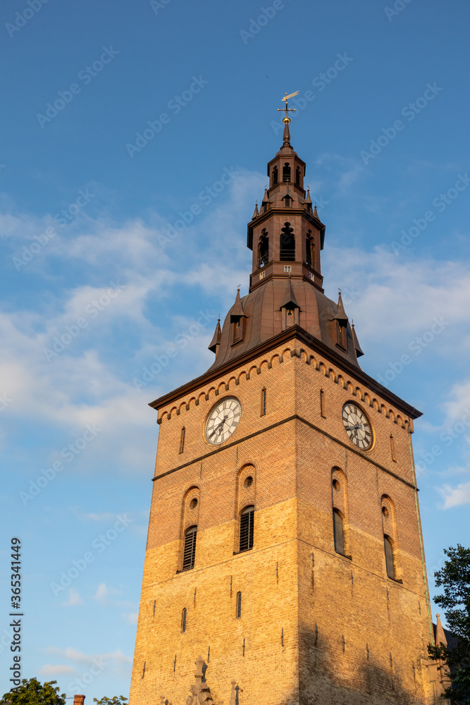 Tower of the Akershus Fortress, waterside fort and former prison on blue sky in Oslo, Norway. European clock tower fort structure landmark