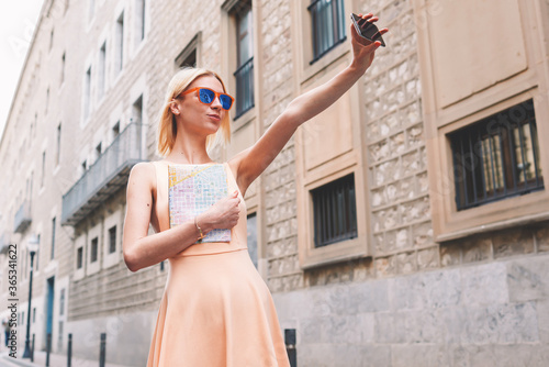 Female tourist using mobile phone camera for take a picture of herself during vacation holidays in Barcelona, stylish young woman taking self portrait with smart phone,feeling good and happy in travel © BullRun