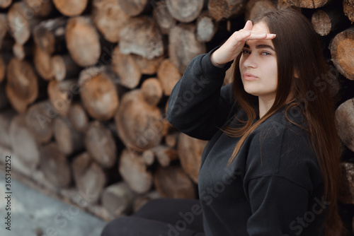 Portrait of young Caucasian woman on the background of chopped wood © Ivan Kozachenko