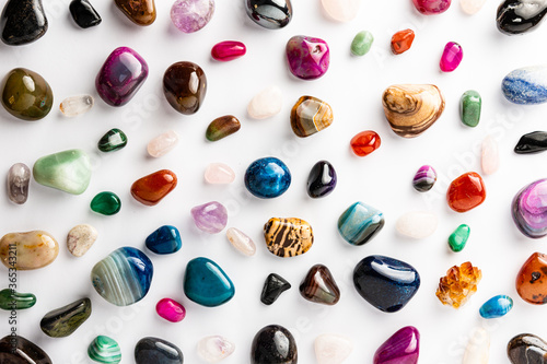 Colorful semi-precious stones arranged neatly on a white background