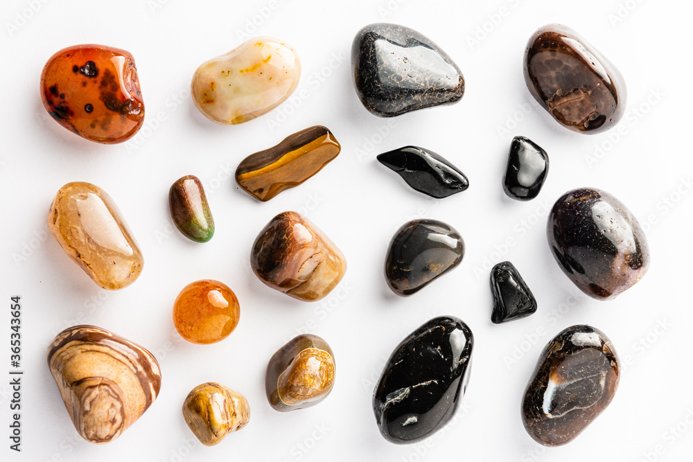 Brown and black semi-precious stones arranged neatly on a white background
