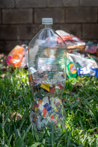 Eco bricks. Bottle stuffed with single-use clean plastic and aluminum packaging materials ready to be recycled.