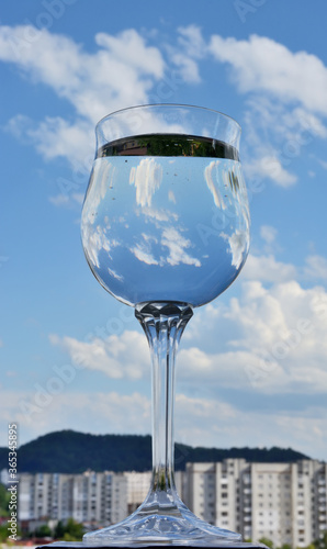 Glass of water with sky reflection