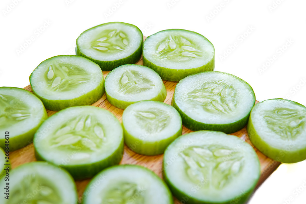 slices of fresh green cucumber on a cutting board. isolated white background slices of fresh green cucumber on a cutting board. isolated white background