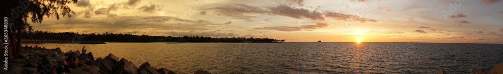 Sunset over the ocean with clouds and orange sky at Bandar Seri Begawan, Brunei.