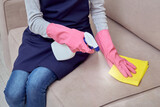 Cleaning of furniture with household chemicals. Girl with gloves.