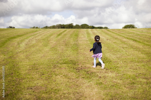 toddler girl running on summer countryside road