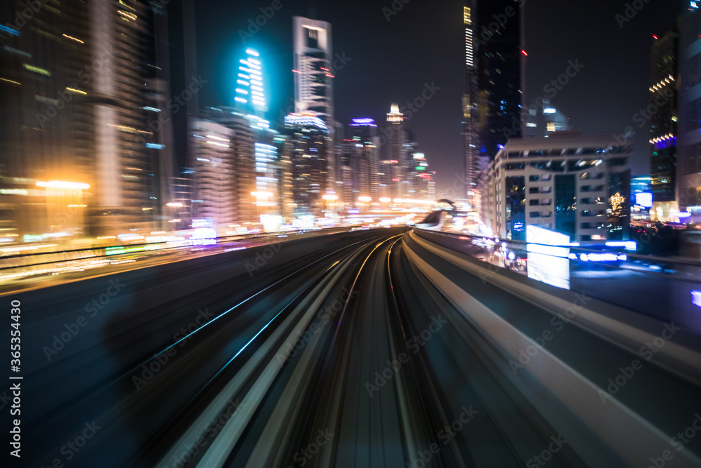 Naklejka premium Tran running on rails in a night city., blurred motion with light.