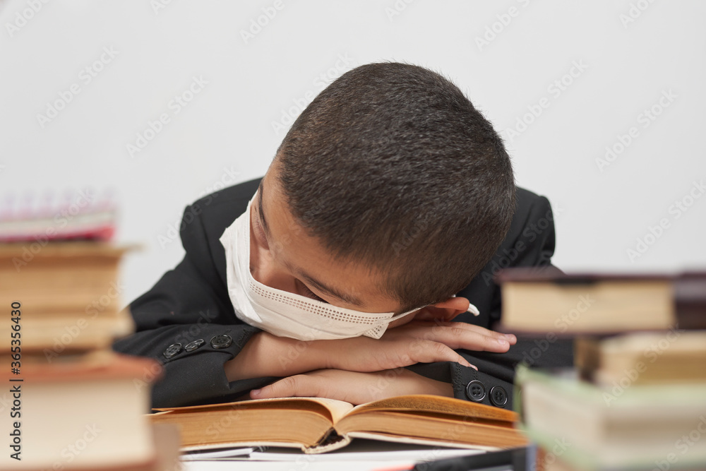 Boy looking tired of doing homework. Schoolboy sleeping in class Boy looking tired of doing homework. Schoolboy sleeping in class