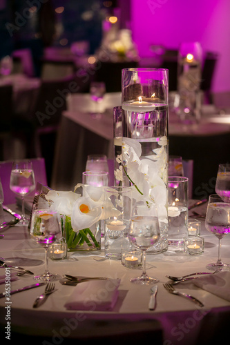 Floating candles on a dimly lit wedding ceremony table with flowers