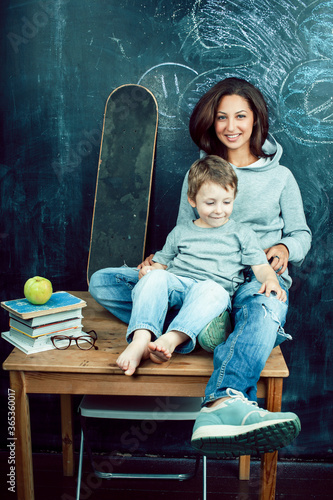little cute boy in glasses with young real teacher, classroom studying, lifestyle people concept