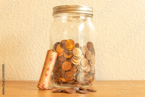 Jar of Pennies and Loose Change on Table Front View Background Financial Saving Concept photo